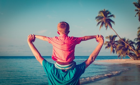 happy father and son playing on seaの写真素材