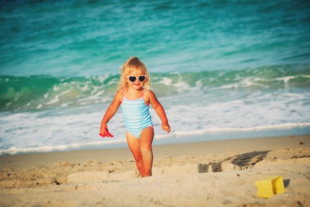 cute little girl play with sand on beachの写真素材