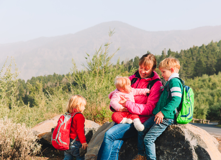 mother with tree kids hiking in mountainsの写真素材