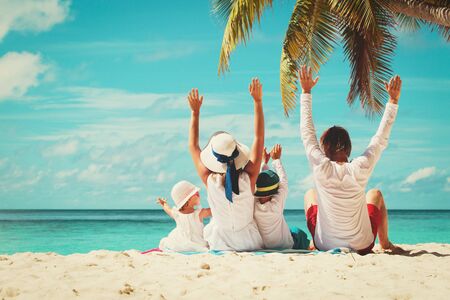 happy family with two kids hands up on beachの写真素材