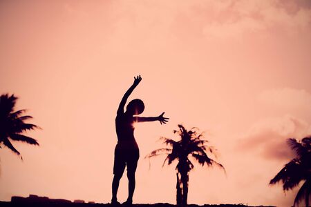 Silhouette of happy little boy play at sunset beachの写真素材