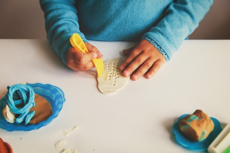 Child playing with clay molding shapesの写真素材