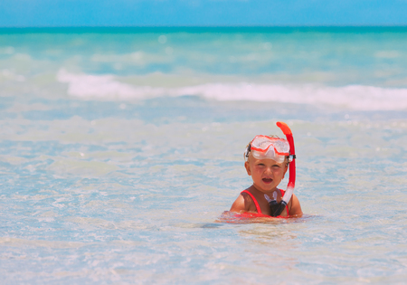 cute little girl learning to swim with diving maksの写真素材