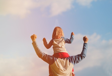 Father and little daughter play at skyの写真素材