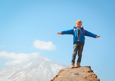 little boy hiking climbing in mountainsの写真素材
