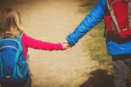 little boy and girl with backpacks going to schoolの写真素材