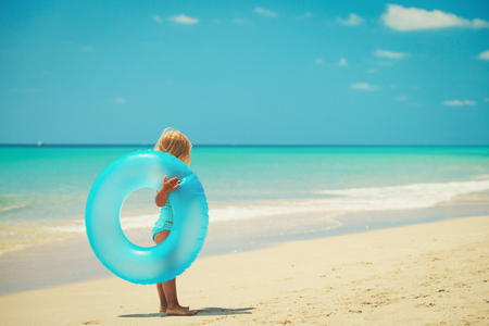 little girl going to swim on beachの写真素材
