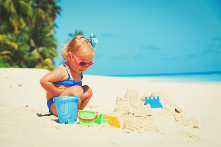 cute little girl play with sand on beachの写真素材
