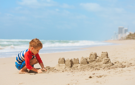 little boy play with sand on beachの写真素材
