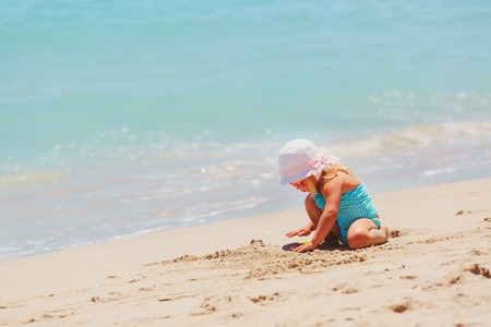 cute little girl play with sand on beachの写真素材