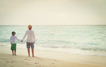 father and little son walking on beachの写真素材
