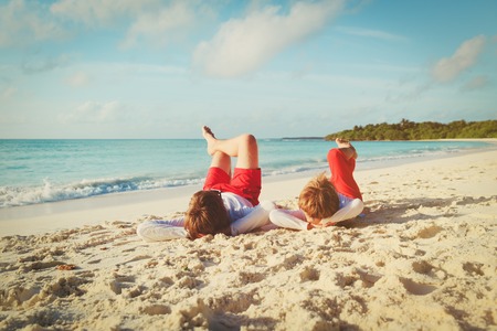 father and little son play on beachの写真素材