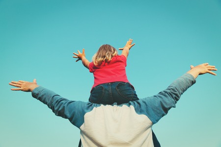 happy father and little daughter play at sky