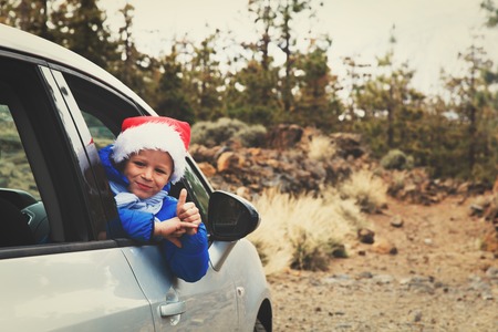 christmas car travel- happy kid travel in mountainsの写真素材