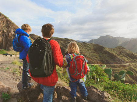 father and two kids hiking travel in mountainsの写真素材
