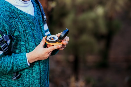 little boy travels with compass in green forestの写真素材