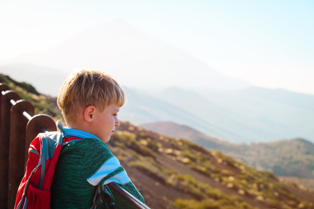 little boy hiking looking at view in mountainsの写真素材