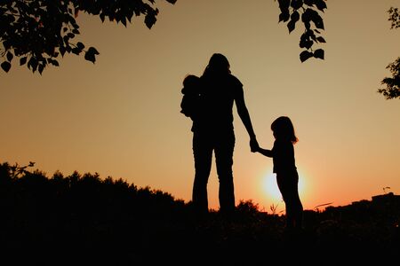 mother with two kids walk in sunset natureの写真素材