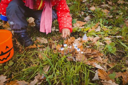 little girl searching for halloween eyeballs, kids trick or treatの写真素材
