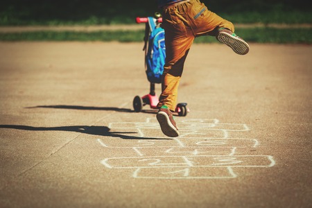 little boy playing hopscotch on playgroundの写真素材