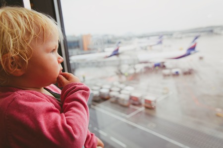 where to go next, travel concept- baby thinking looking at planesの写真素材