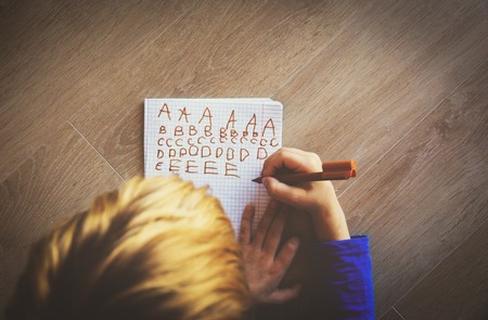 little boy learning to write letters doing homework