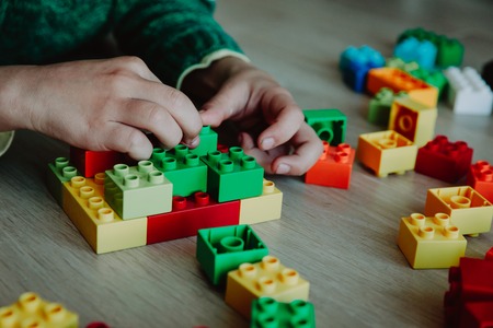 little boy building from colorful plastic blocks