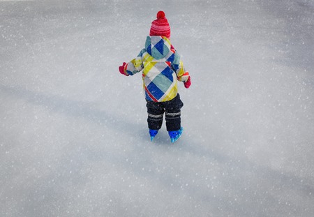 little girl learning to skate in winterの写真素材