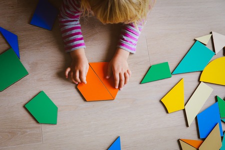 little girl playing with puzzle in school or daycareの写真素材