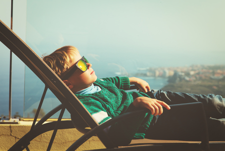 little boy relax on balcony with scenic viewの写真素材