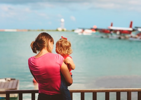 mother and little daughter waiting for sea plane, travel concept
