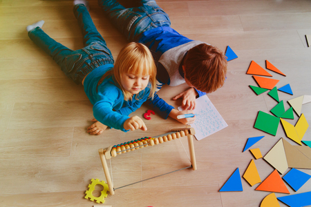 little boy and girl learn to write and calculate numbersの写真素材