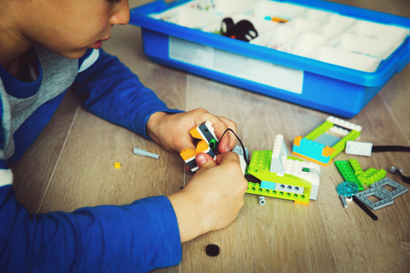 teenage boy building from colorful plastic blocksの写真素材