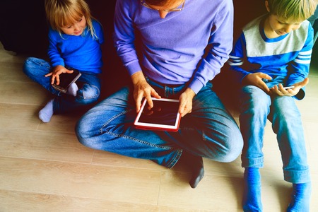father with kids using toch pad and mobile phones