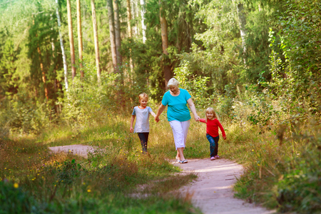 happy senior grandmother with kids walk in natureの写真素材