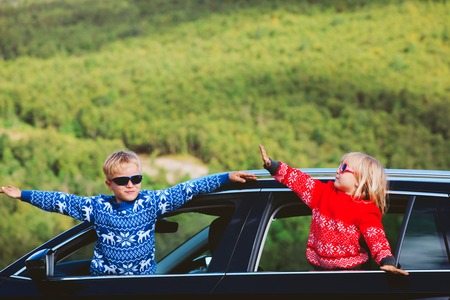 happy little boy and girl travel by carの写真素材