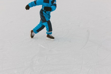 little boy skating on ice in winterの写真素材