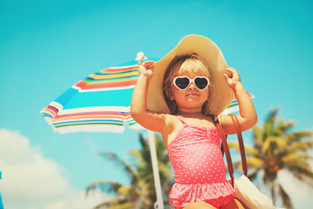 cute little girl with big bag on beachの写真素材