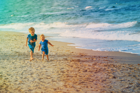 little boy and girl run play at beachの写真素材