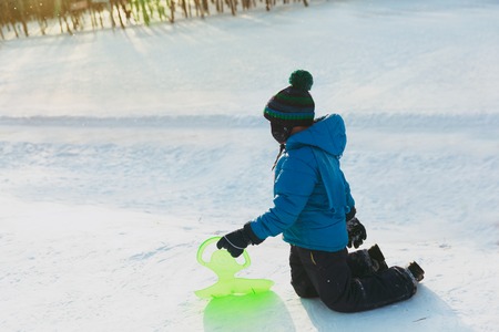 little boy get ready to slide in winter snowの写真素材
