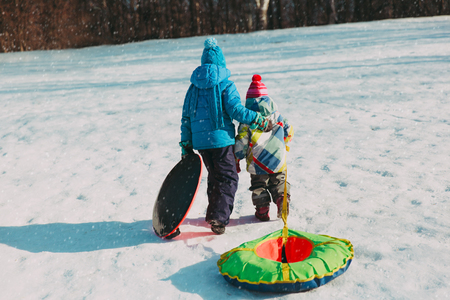 little boy and girl go for winter slideの写真素材