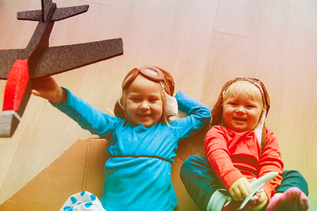 happy kids with helmet and glasses play with toy planesの写真素材