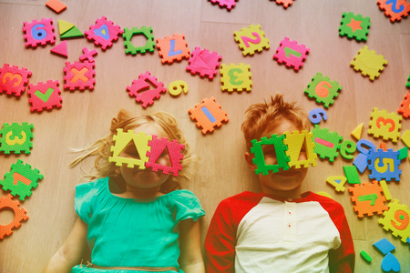 happy little girl and boy learn numbers and shapesの写真素材