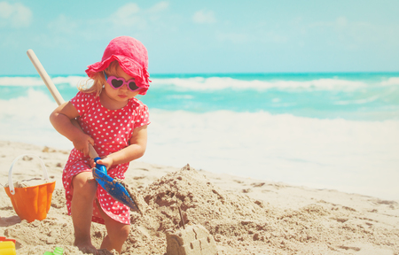 cute little girl play with sand on beachの写真素材