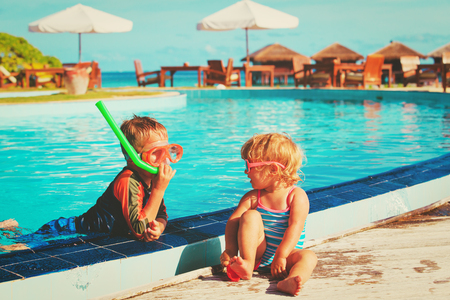little boy and girl playing in swimming pool at beachの写真素材