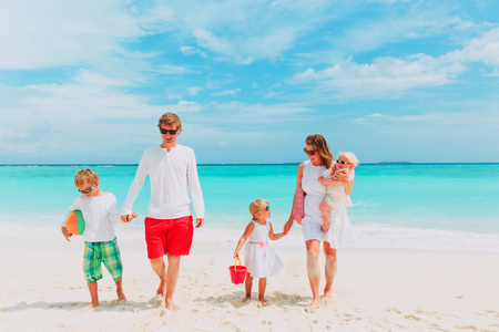 happy family with three kids walk on beachの写真素材