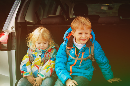happy little boy and girl travel by carの写真素材