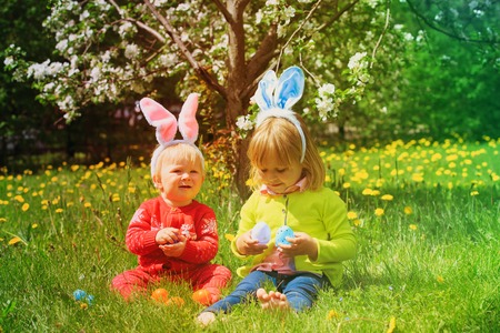 happy kids on easter eggs hunt in springの写真素材