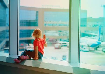 little girl looking at planes in airportの写真素材
