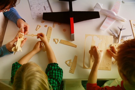 teacher and kids making toy wooden planesの写真素材